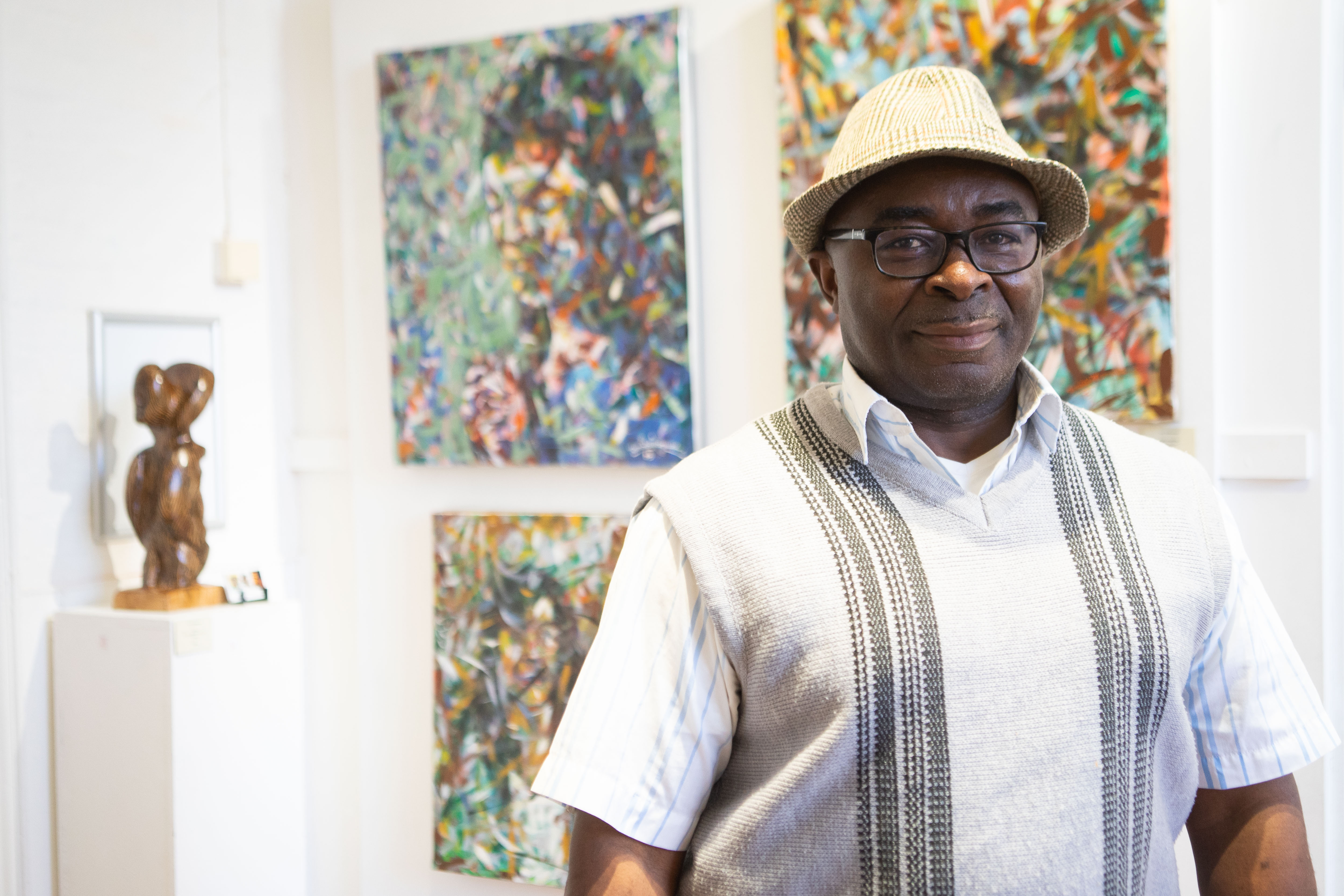 Toni Ndikanwu, the artist, stood in front of his art work