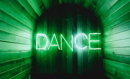 A photo of a neon sign with the word "Dance"