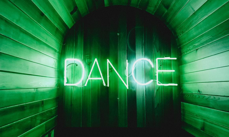 A photo of a neon sign with the word "Dance"